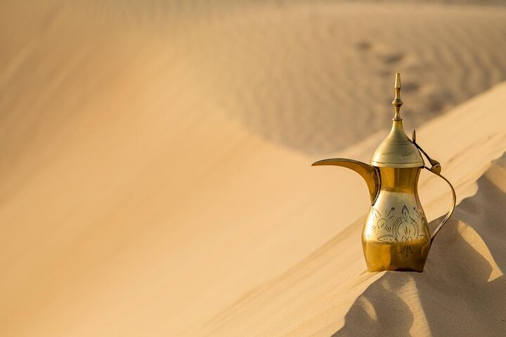 Discover the beauty of endless golden dunes and traditional Emirati charm with a stunning coffee pot inviting travelers to immerse themselves in the spirit of Dubai's desert adventures.
